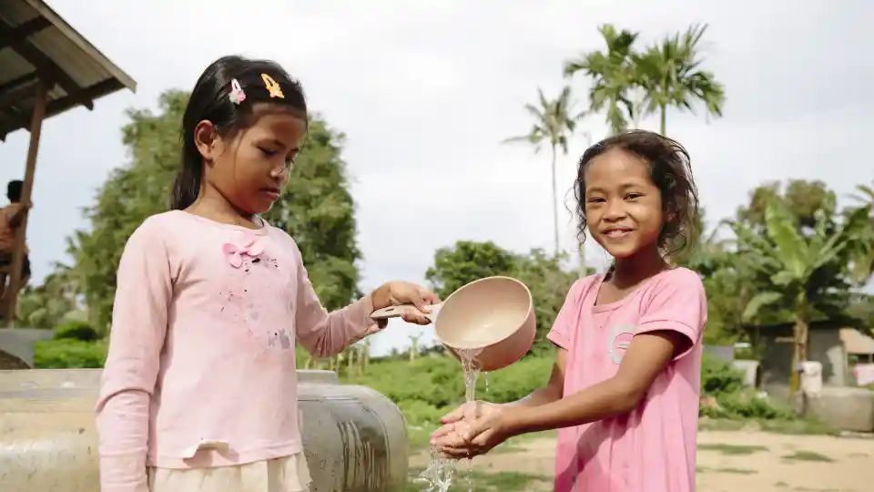 Handwashing: Vuth Raksa, 9 – girl in pink with curly hair Kim Leang, 10 – girl in long sleaved pink top and hair tied back. Prek Bei community/village, Samroang Commune, Phnom Kravanh District, Pursat Province,  Cambodia.