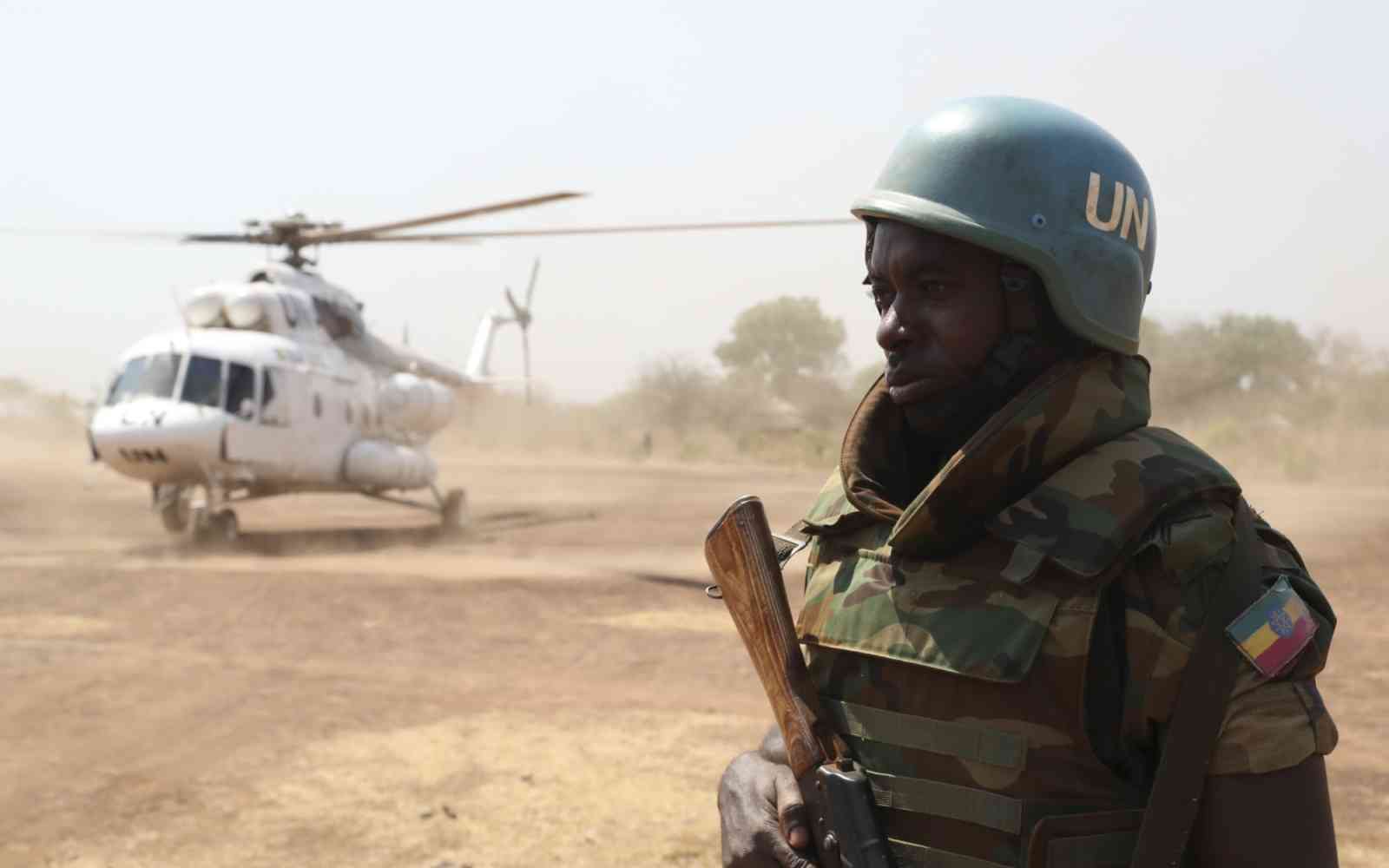 An Ethiopian peacekeeper serving with the United Nations Mission in South Sudan (UNMISS), stands guard near an UNMISS helicopter at an airbase in Mundri.