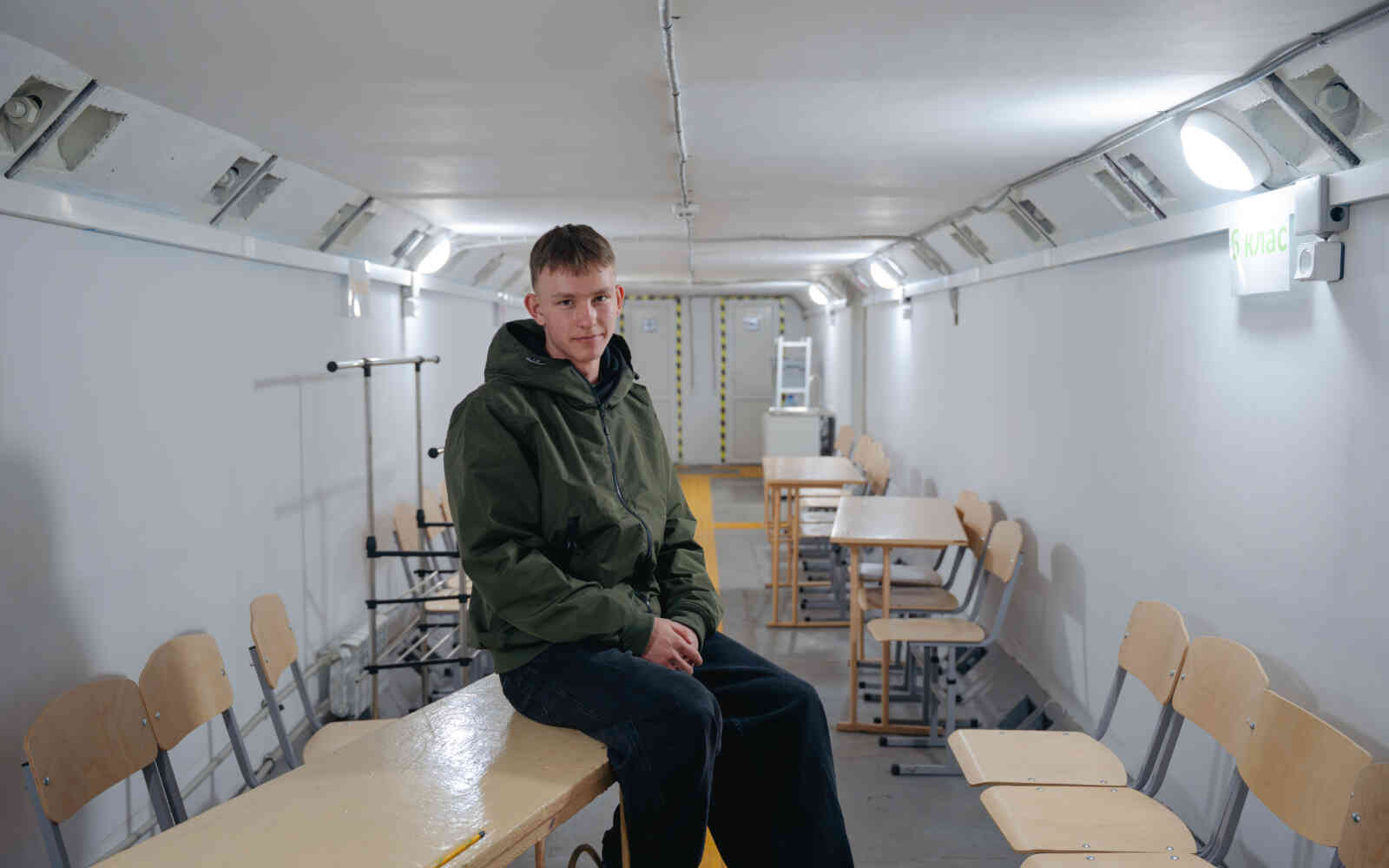 Denys, an 11th-grade student at Pisky Secondary School, sits in the shelter. ©UNOPS/Veronika Yaresko