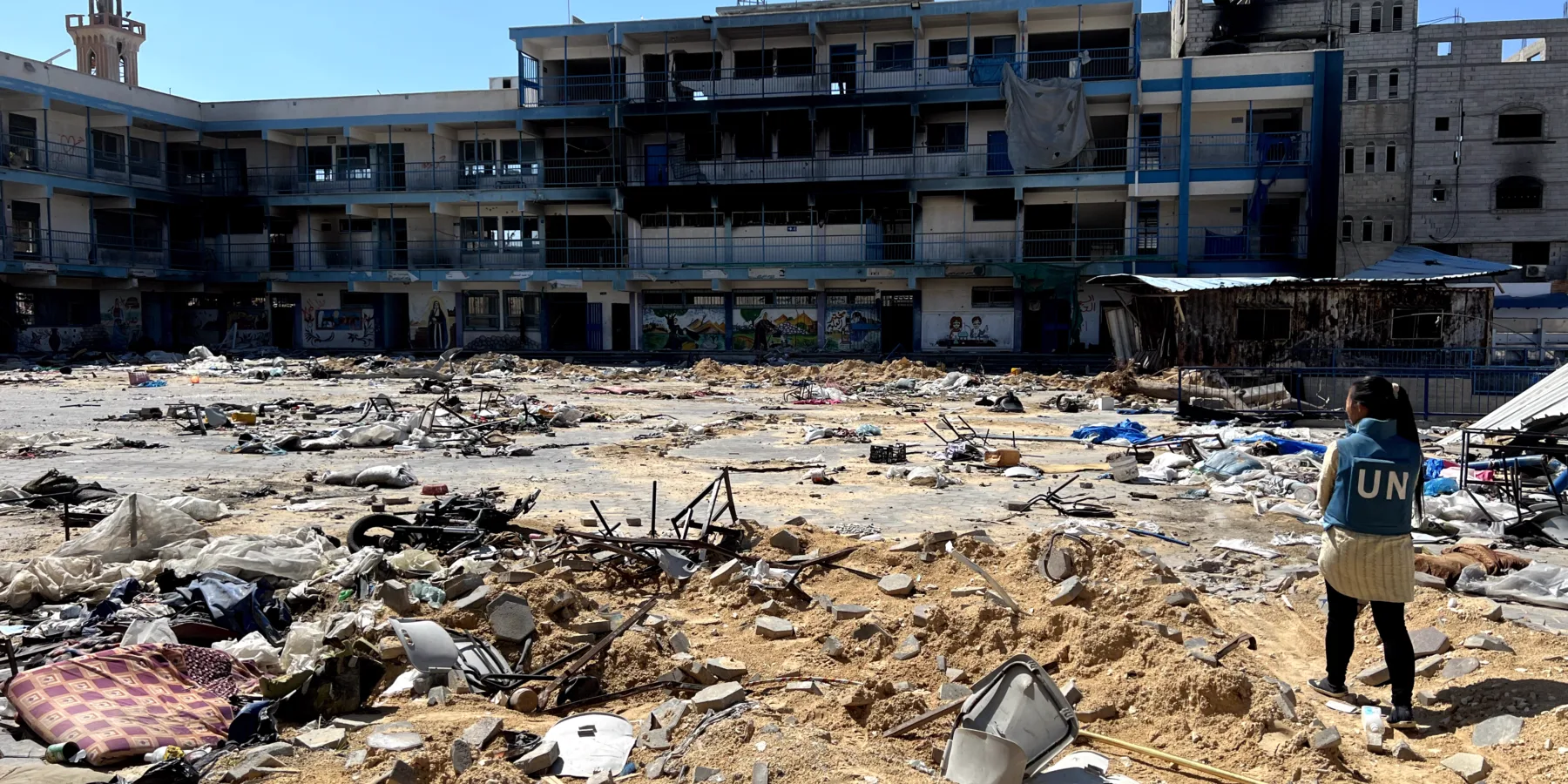 Una trabajadora de Naciones Unidas observa los daños en una escuela en Gaza.