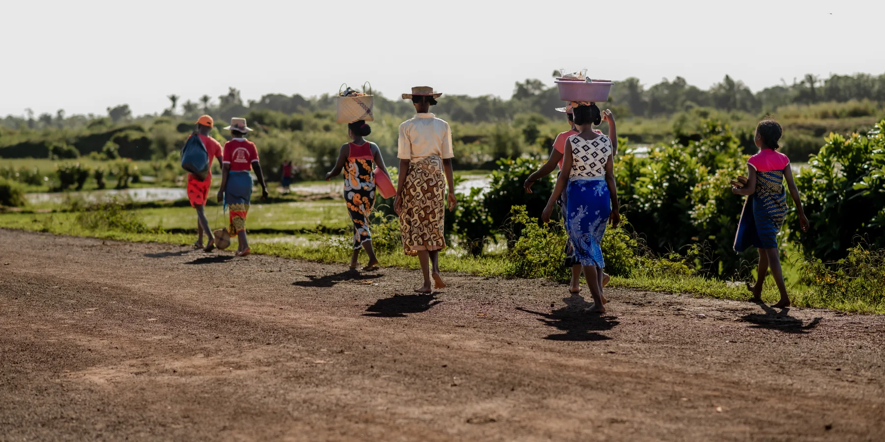 Varias personas caminan por una carretera recién rehabilitada en la región de Fitovinany (Madagascar). © UNOPS/Harzoon Razafimandimby