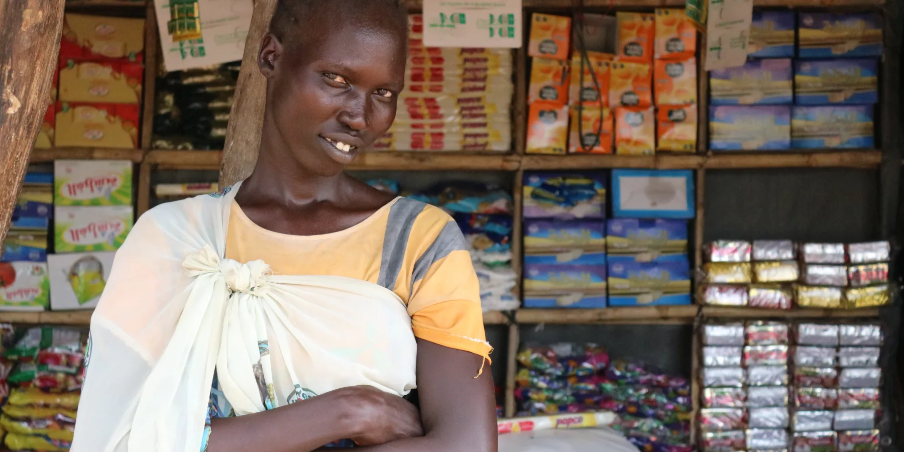 Angelina Deng, comerciante del mercado de Ayien, delante de sus productos.