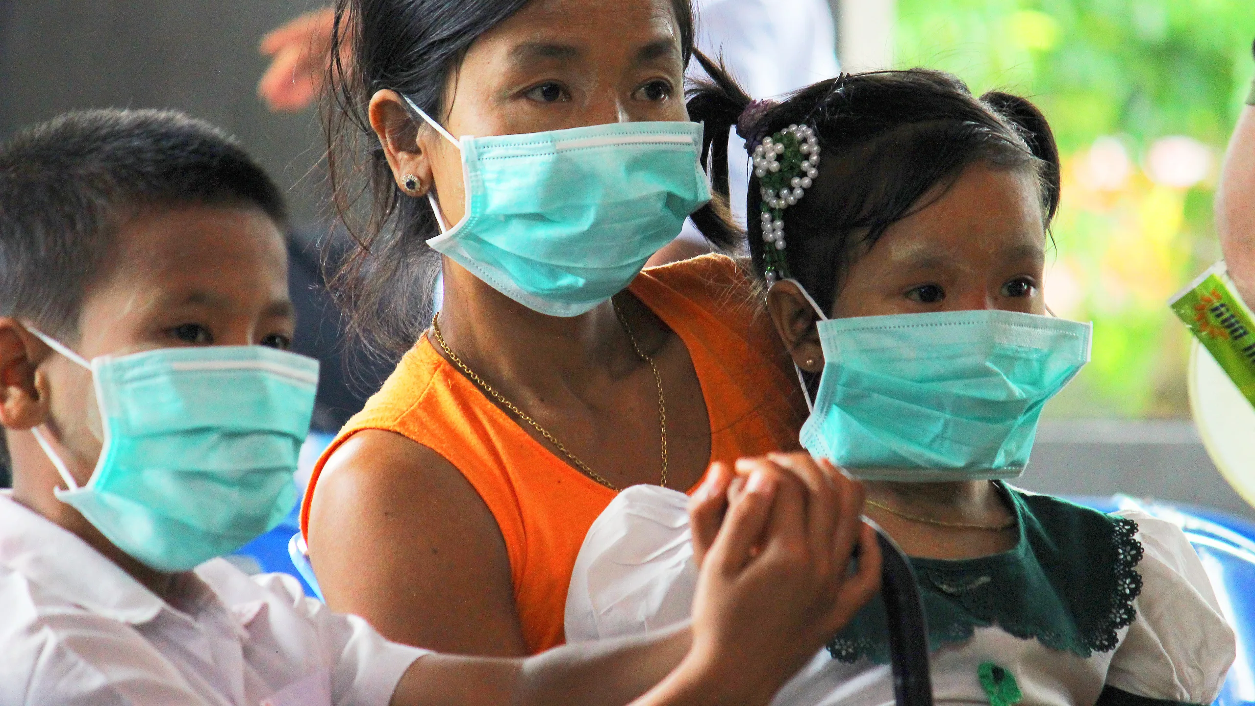 Una mujer y sus hijos reciben información sobre los síntomas y el tratamiento para la tuberculosis en Myanmar.