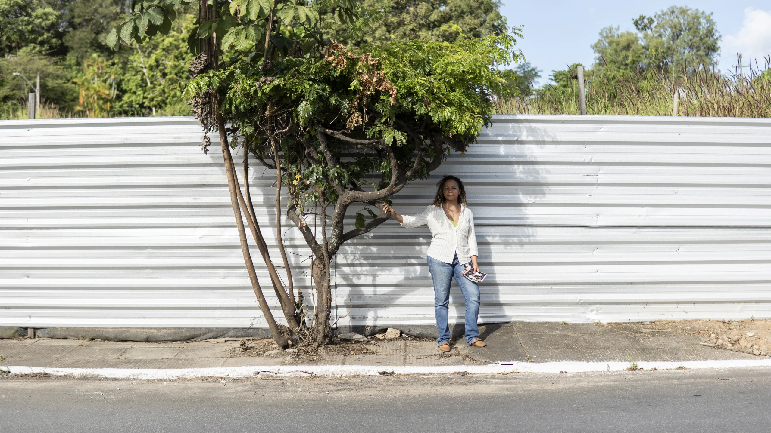 Roberta Santos stands before the tree her family planted – the only thing left where their home once stood