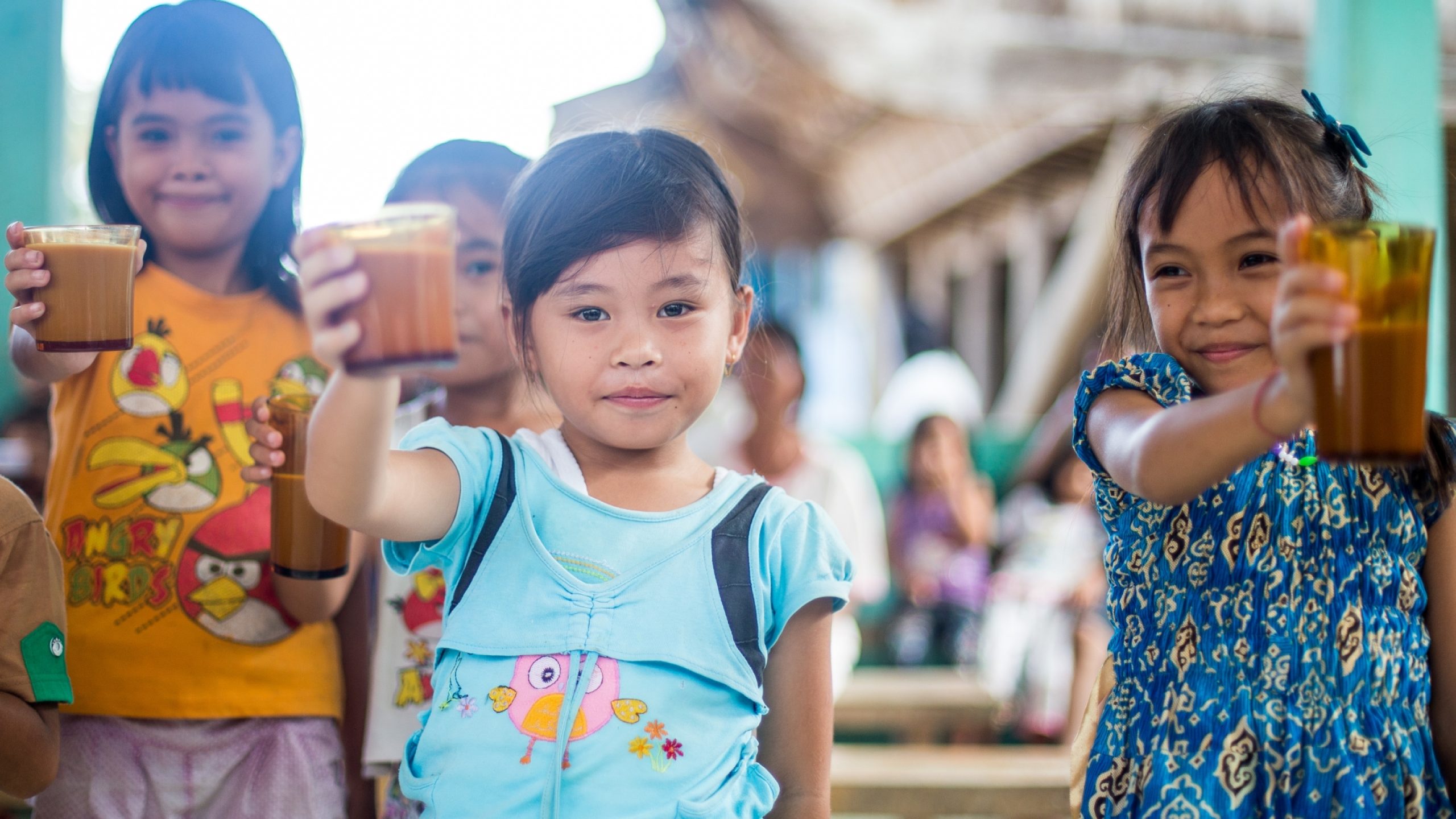 De jeunes Indonésiennes boivent leur médicament contre la tuberculose avec un verre de lait.