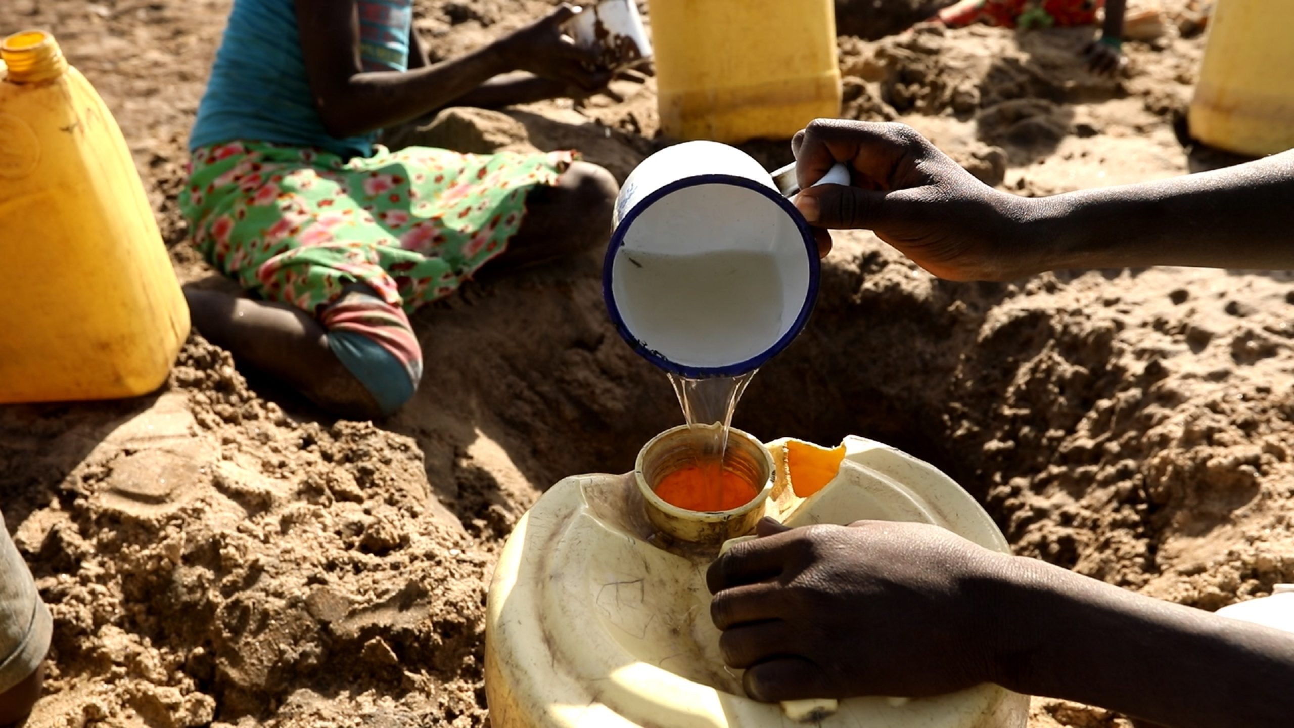 Ils extraient le plus d’eau possible de cette ouverture dans la terre avant de reprendre la longue marche pour rentrer chez eux.