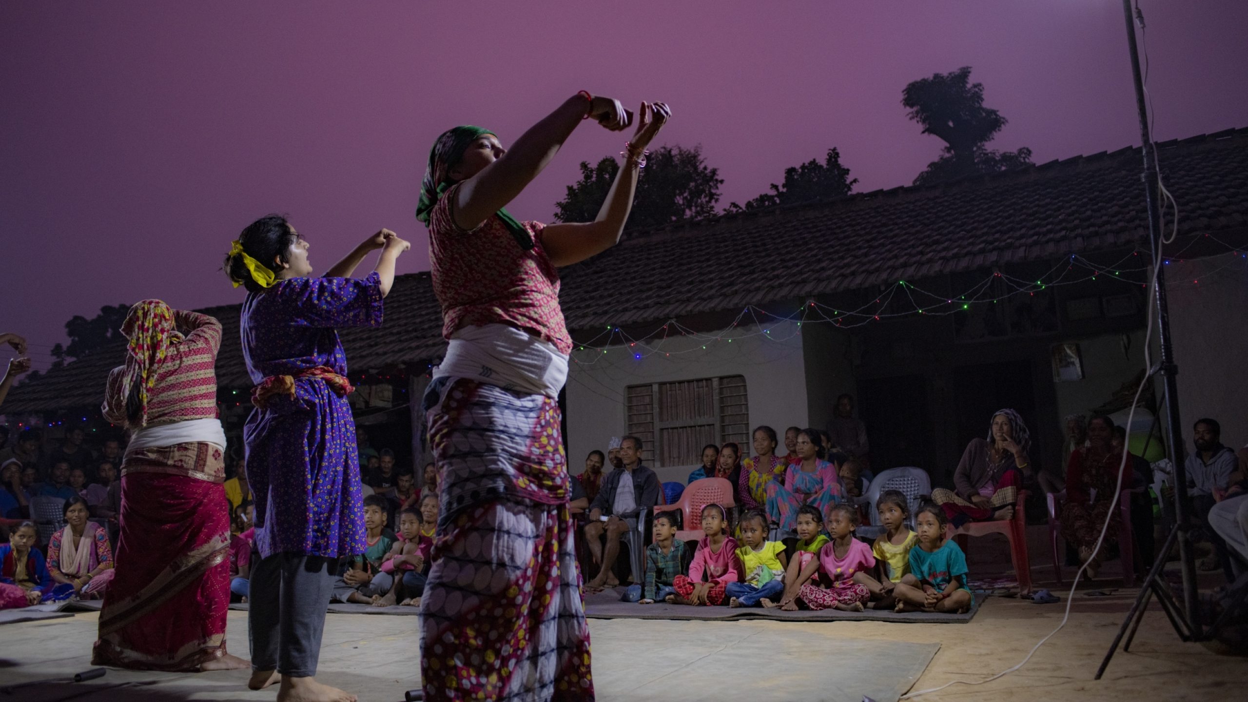 La troupe de théâtre se produit à Kailali, dans le district de Kanchanpur. En scène, des femmes expliquent les difficultés du travail dans les champs (les femmes sont principalement responsables du travail de la terre et des tâches ménagères).