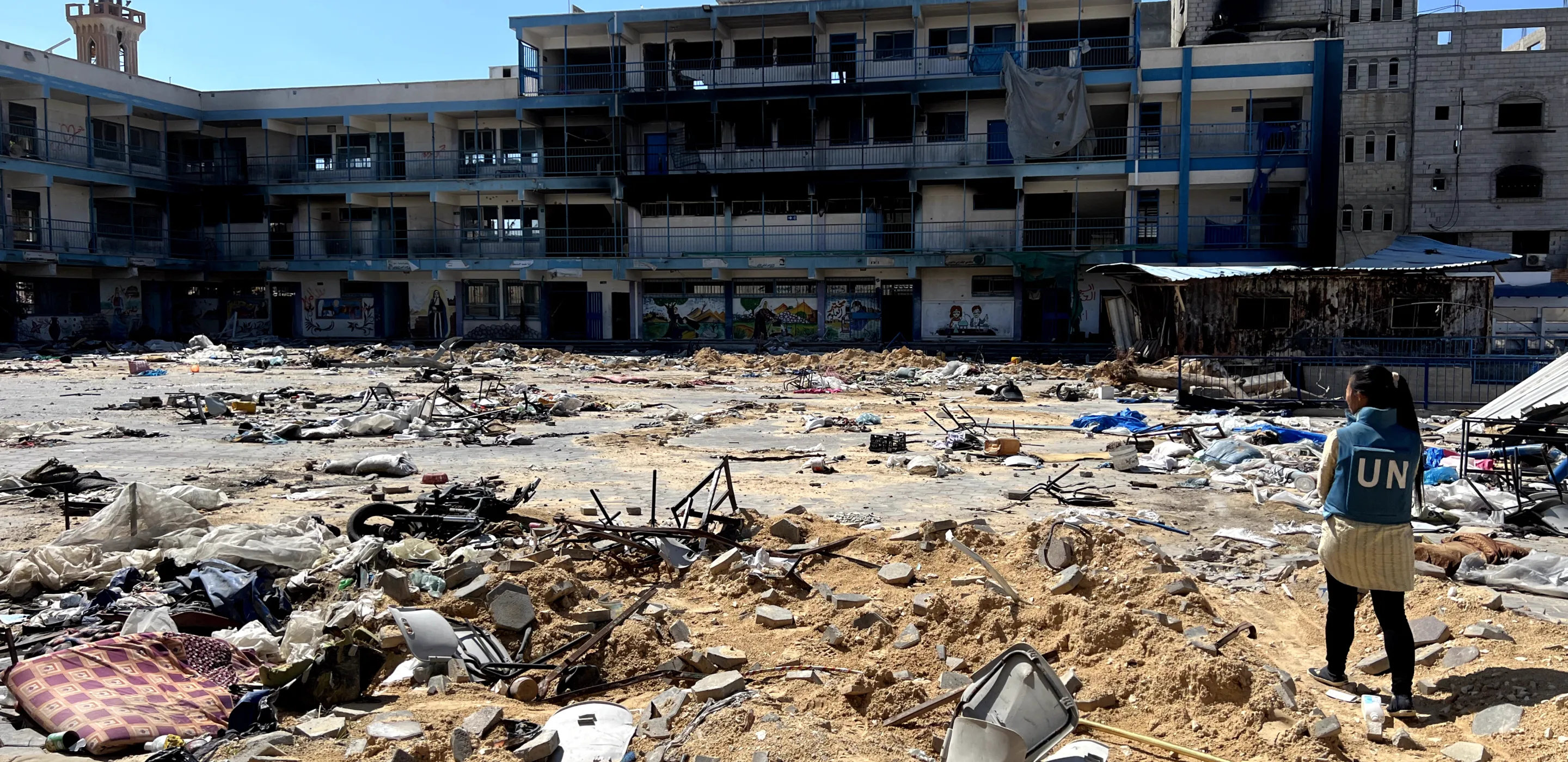 Une travailleuse humanitaire examine une école endommagée à Gaza.
