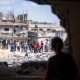 Un groupe de personnes examine les dommages subis par une zone résidentielle dans la bande de Gaza. ©OMS