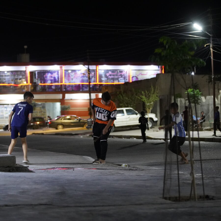 Kids play on lit neighbourhoods in the dark in Sinjar, Iraq.