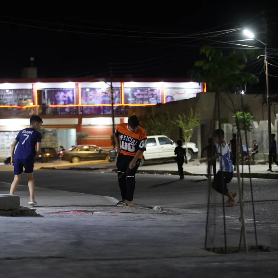 Kids play on lit neighbourhoods in the dark in Sinjar, Iraq.