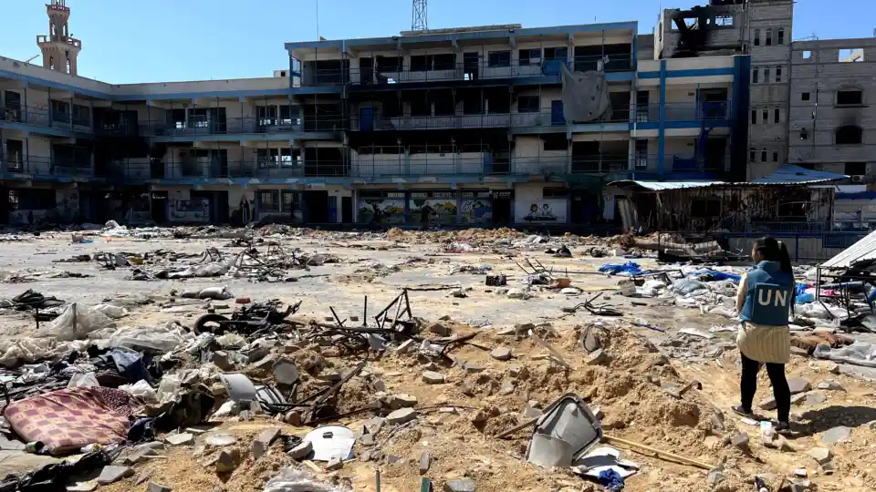 A UN aid worker examines damaged school in Gaza.