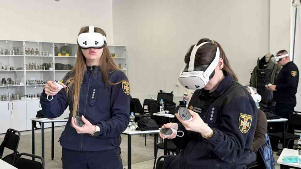 Ukraine’s State Emergency Service experts interact with the virtual reality application during a training session.