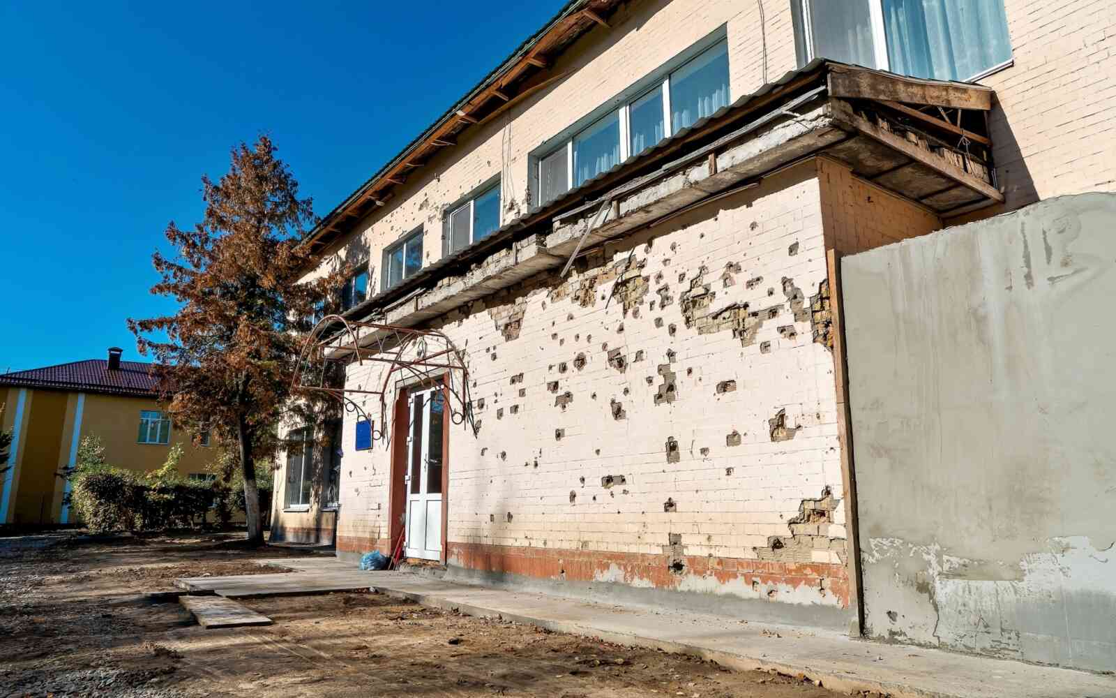 Antes: La fachada del centro preescolar tras el impacto de un misil, donde pueden verse los daños causados por la metralla en las paredes.