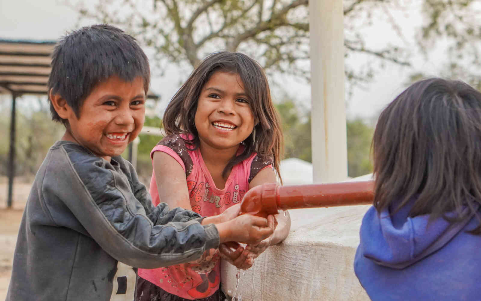 Children play at a new water cistern in Santa Victoria Este, Argentina, 2024