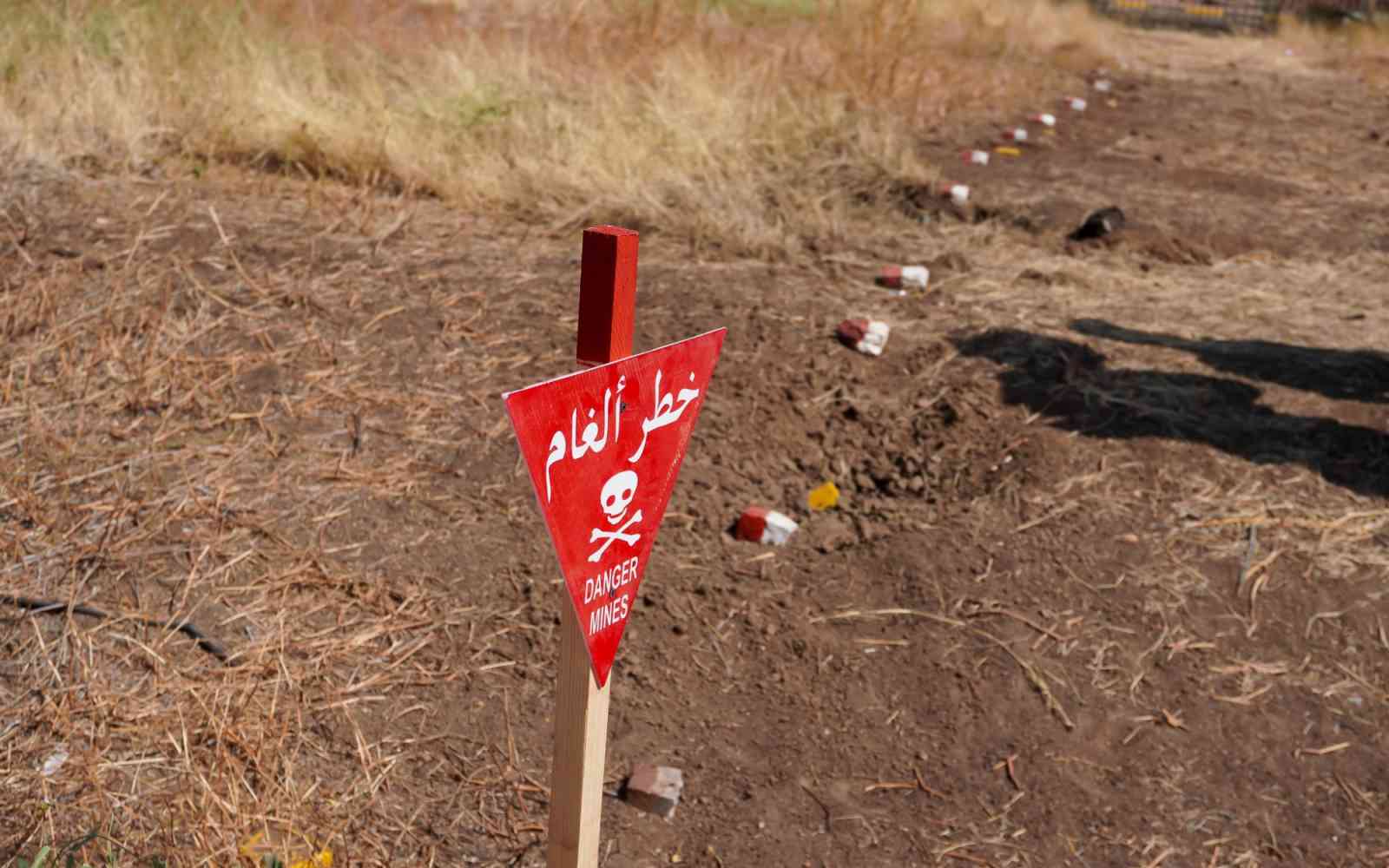 A warning sign marks a hazardous area in central Khartoum. Widespread contamination restricts movement and endangers civilians returning to their homes.