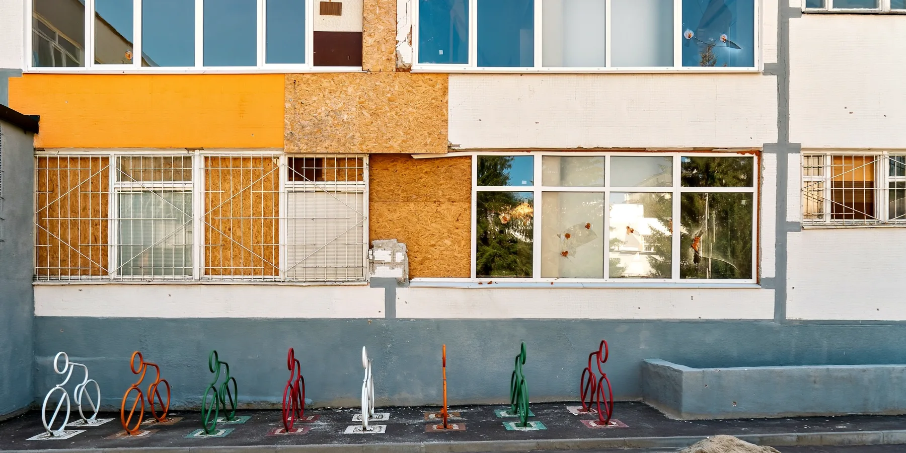 The school facade was damaged in a series of explosions. Only the newly  installed bicycle parking served as a reminder of pre-war life.