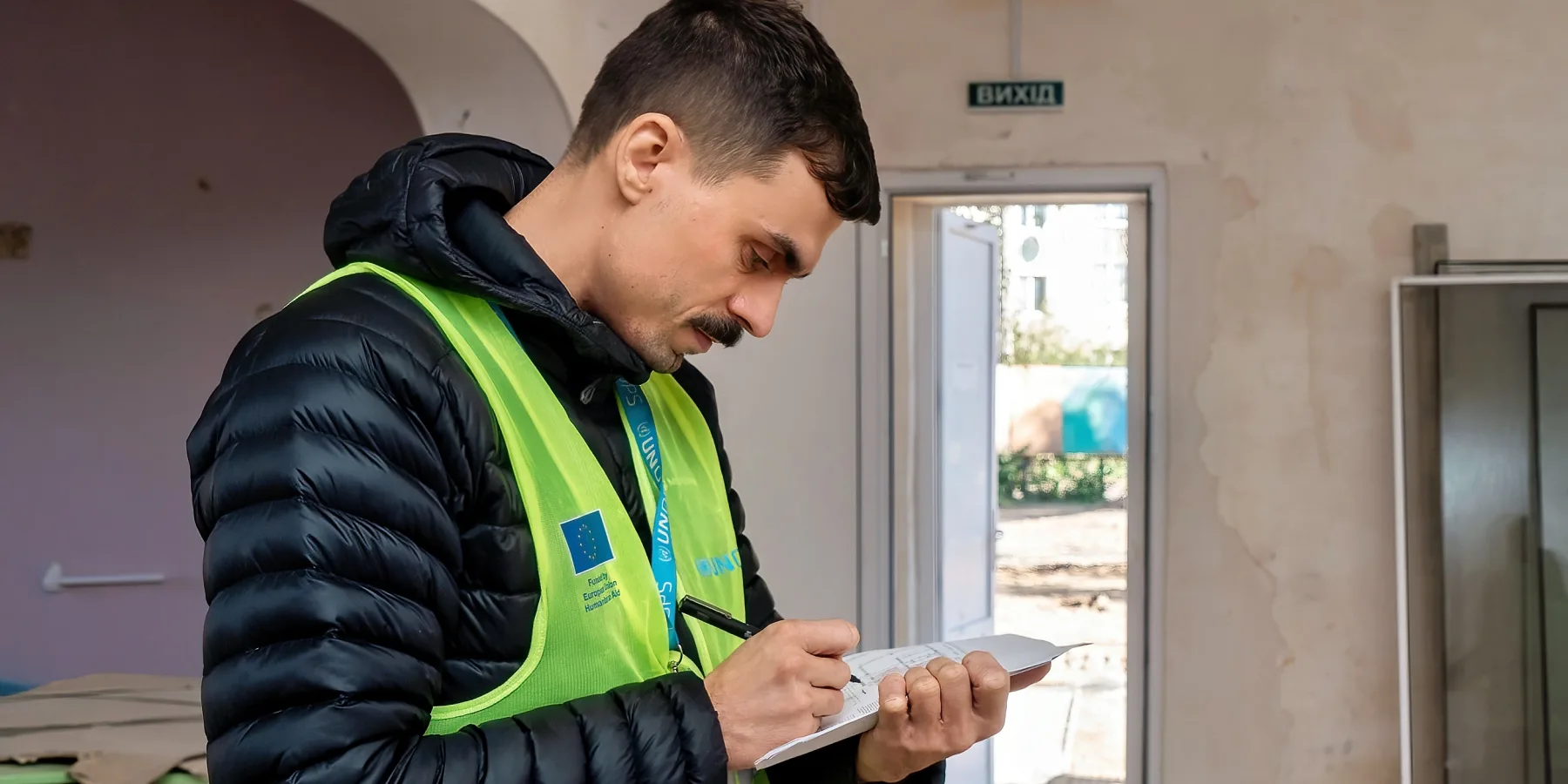 A UNOPS engineer assesses and documents the structural damage inside the building.