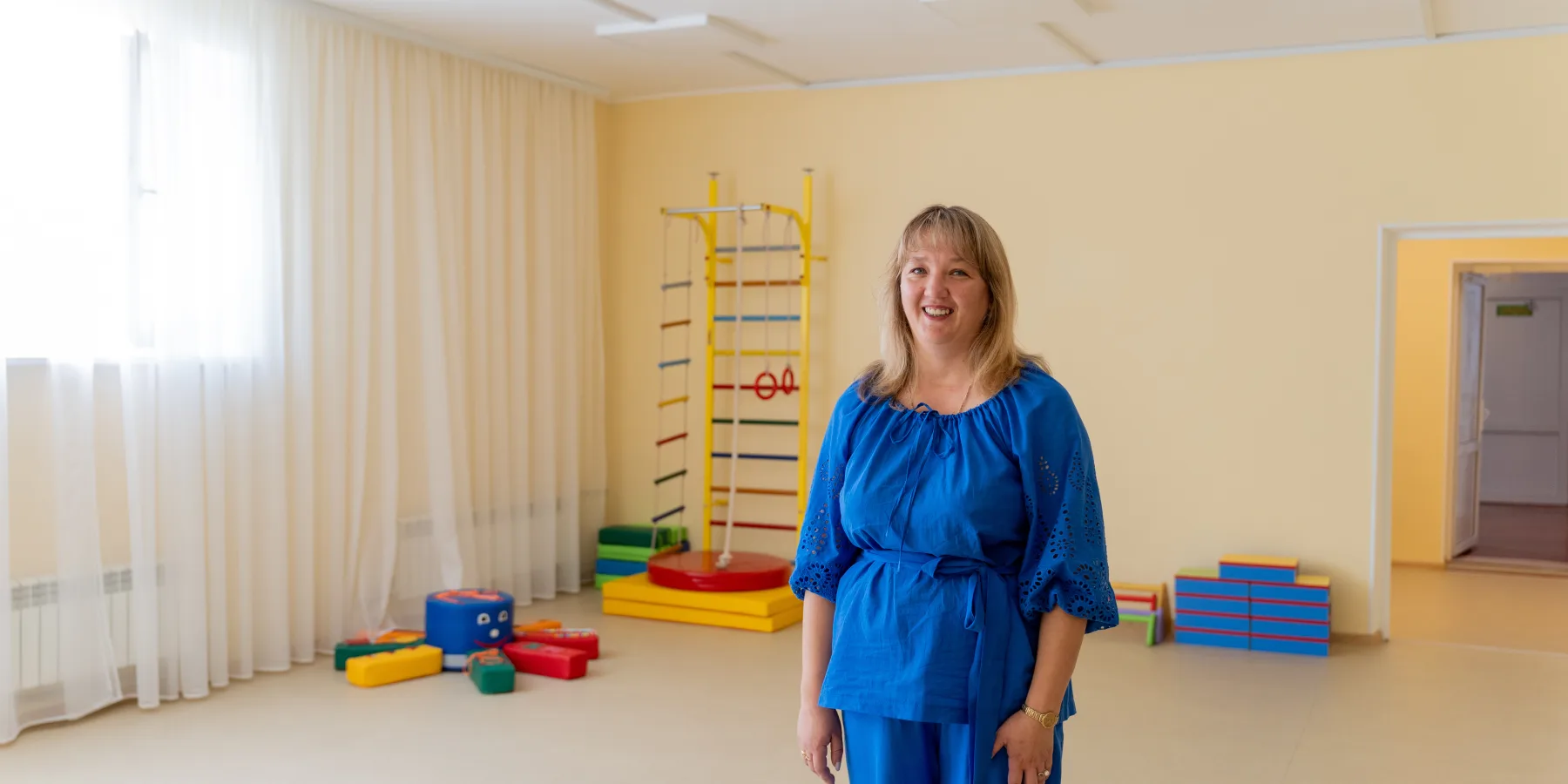 Oksana Petruk, Head of the Preschool Institution, standing in a newly renovated classroom.