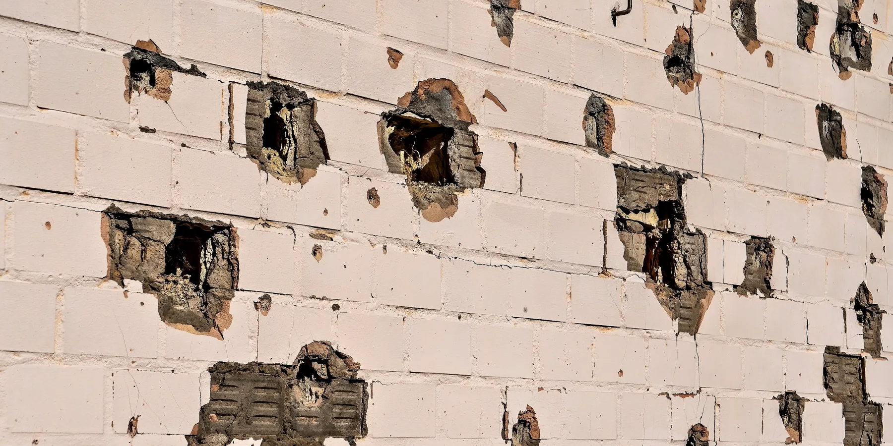 The preschool's facade after a missile strike, showing shrapnel damage on the walls.
