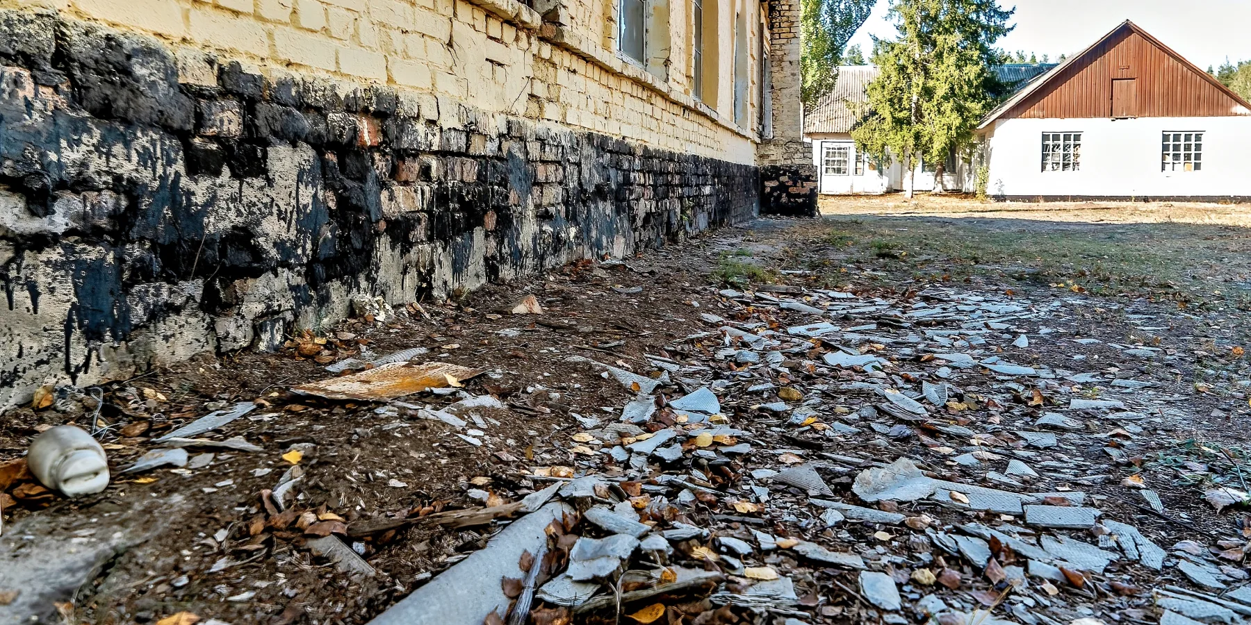 The exterior of a college building shows fire damage and debris after Russian military units were stationed on the grounds.