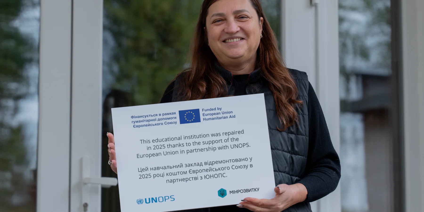 La Directora de la escuela con una placa conmemorativa emitida por su participación en el proyecto, que se instalará en la fachada de la escuela.