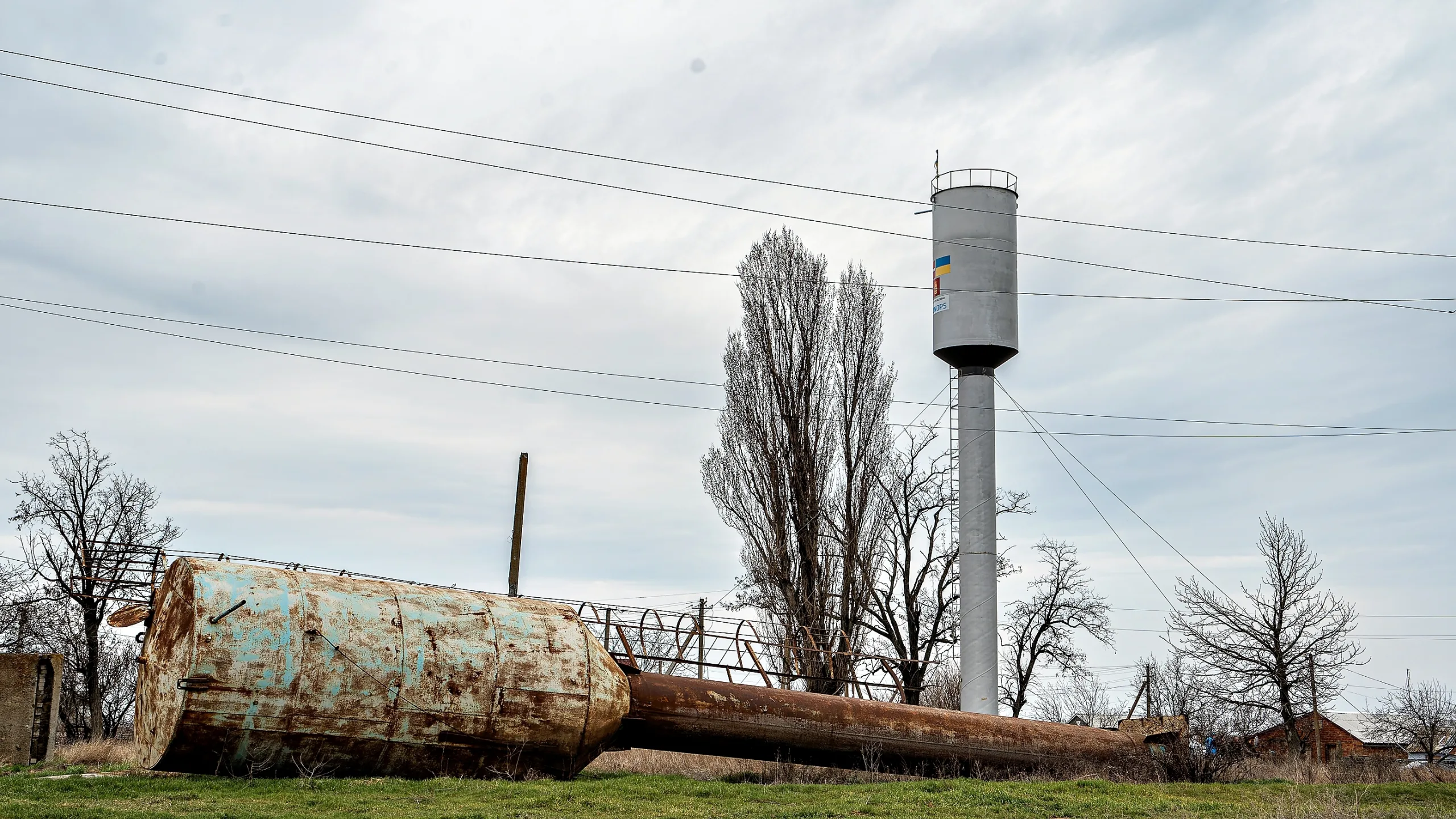 Una antigua torre de agua oxidada y fuera de servicio junto a una torre recién instalada. Una de las varias adquiridas por UNOPS para mejorar la infraestructura hídrica en la región de Mykolaiv.