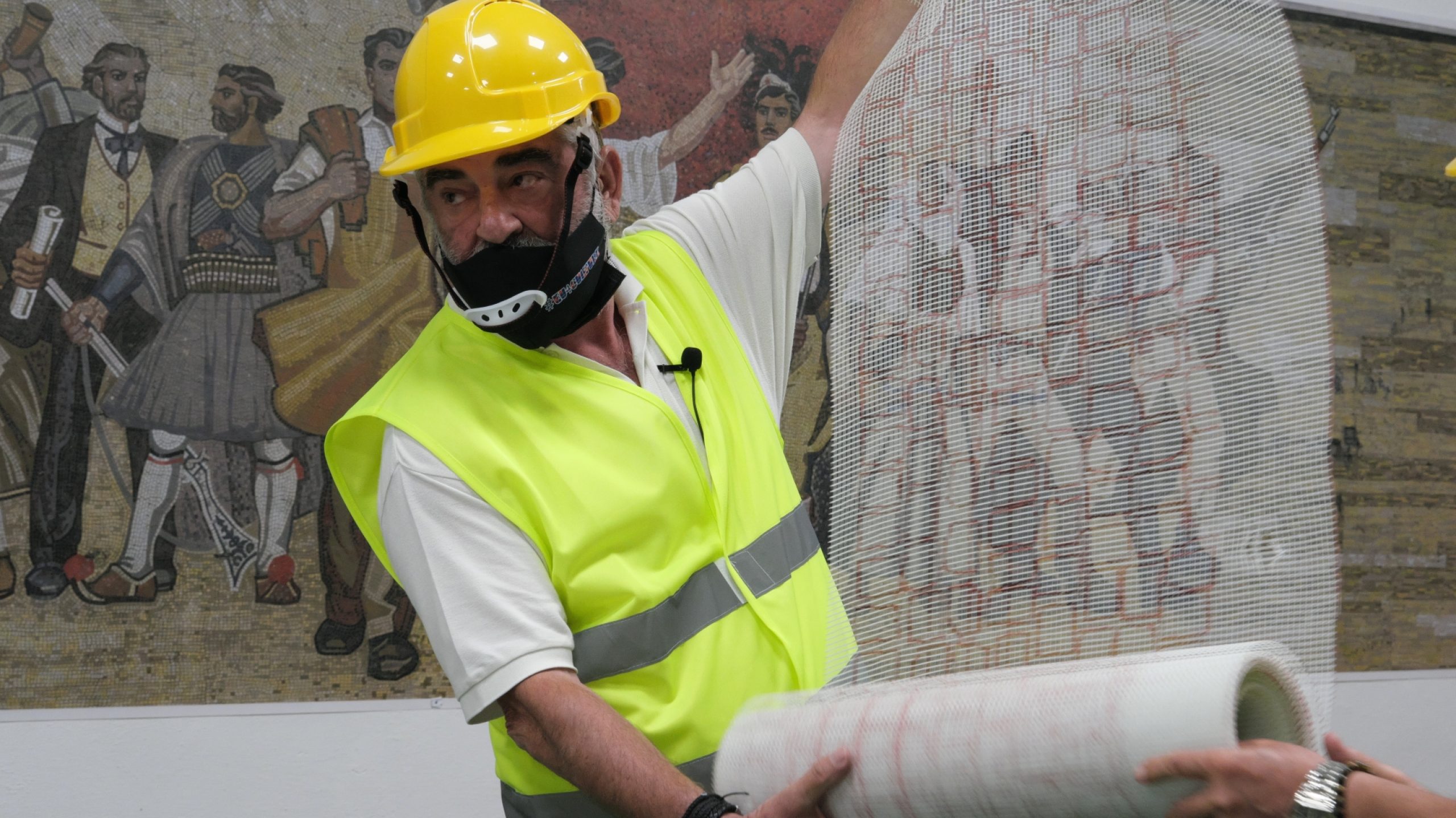 An expert displays the stencil of the mosaic, a technique used to trace the design.
