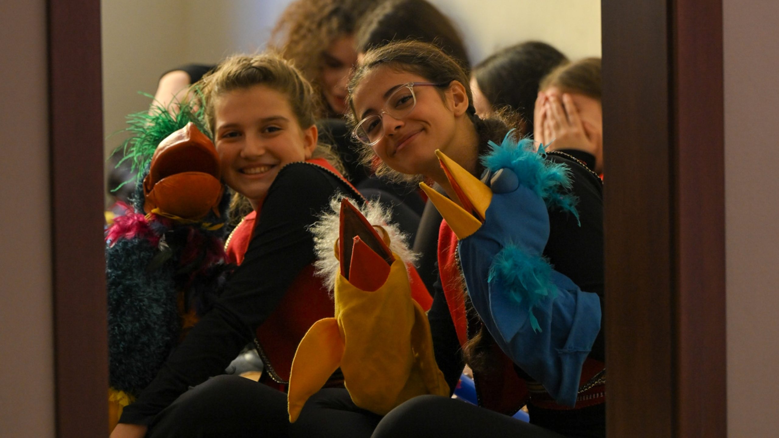 Jóvenes artistas sonríen entre bastidores en el Teatro Nacional de Marionetas, a punto de dar vida a sus marionetas para una nueva generación de espectadores y espectadoras.
