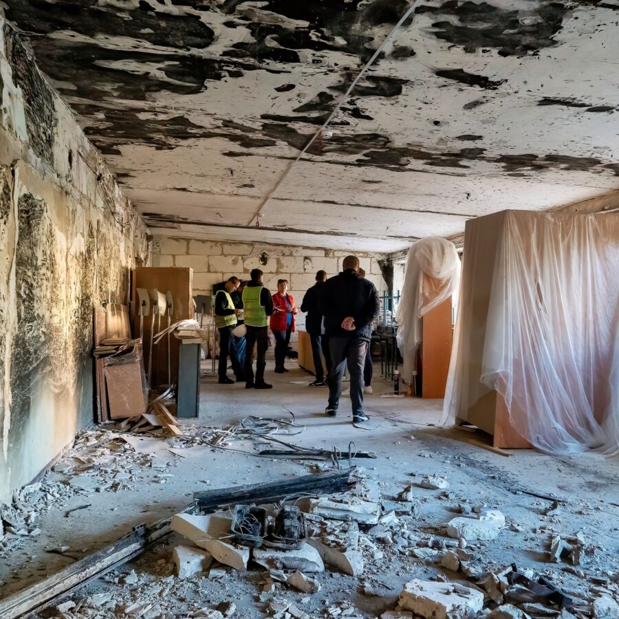 Inspección de uno de los talleres de la escuela dañados por un incendio al comienzo de la guerra.