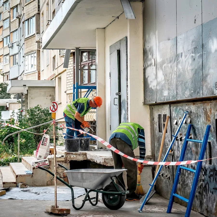 Travaux visant à réparer une entrée d’un immeuble résidentiel dans le nord du district de Saltivka, à Kharkiv.