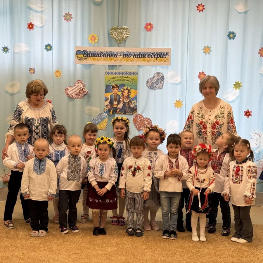 Children and their teachers, dressed in traditional Ukrainian vyshyvankas, pose together to celebrate their long-awaited return to the restored preschool.