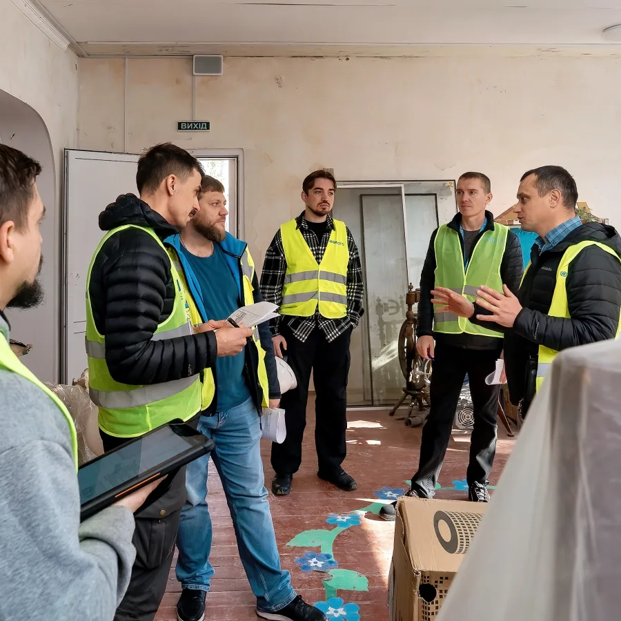 Engineers and contractors meet inside the damaged preschool to coordinate repair efforts, collaborating to bring the facility back to life.