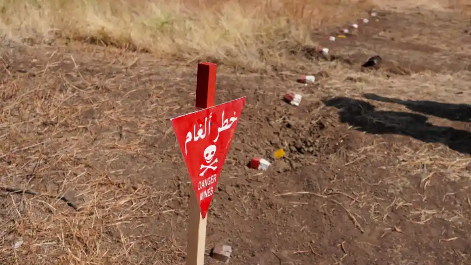 A warning sign marks a hazardous area in central Khartoum. Widespread contamination restricts movement and endangers civilians returning to their homes.
